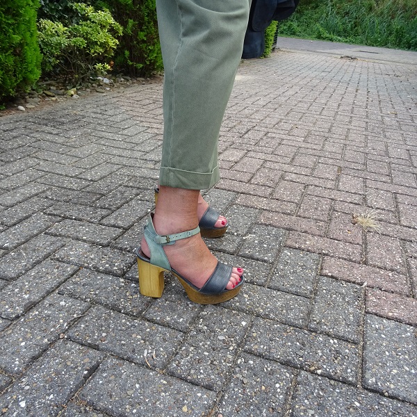 blue sandals under green baggy trousers