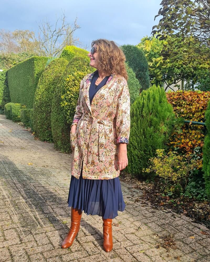 golden coat on navy pleated dress