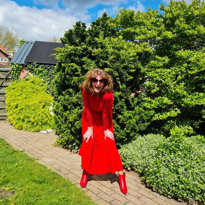 red ankle boots under a red pleated skirt