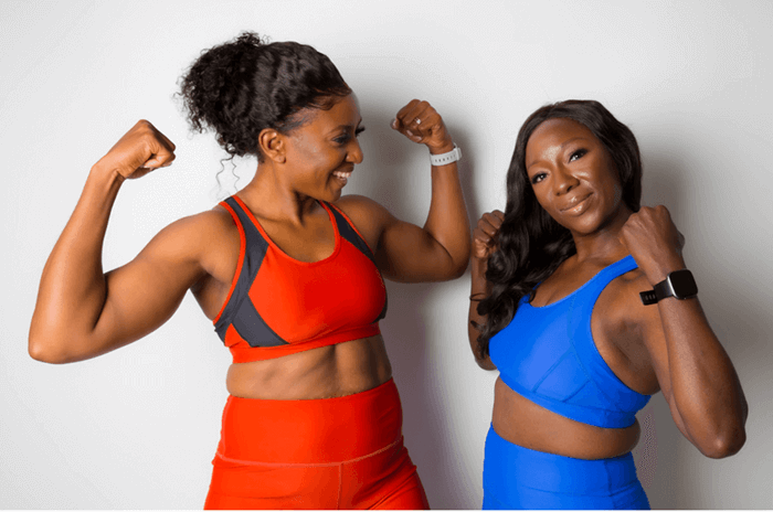 team accessories woman in red sports bra beside woman in blue sports bra